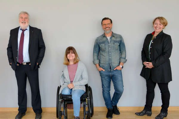 Zwei Damen, eine davon im Rollstuhl, und zwei Herren  